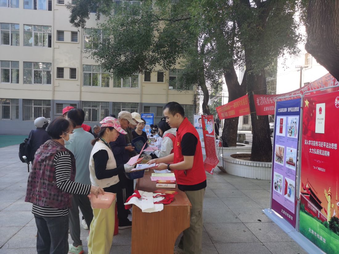 图为北海市档案馆志愿者向居民发放普法宣传资料.（方思琴摄）.jpg