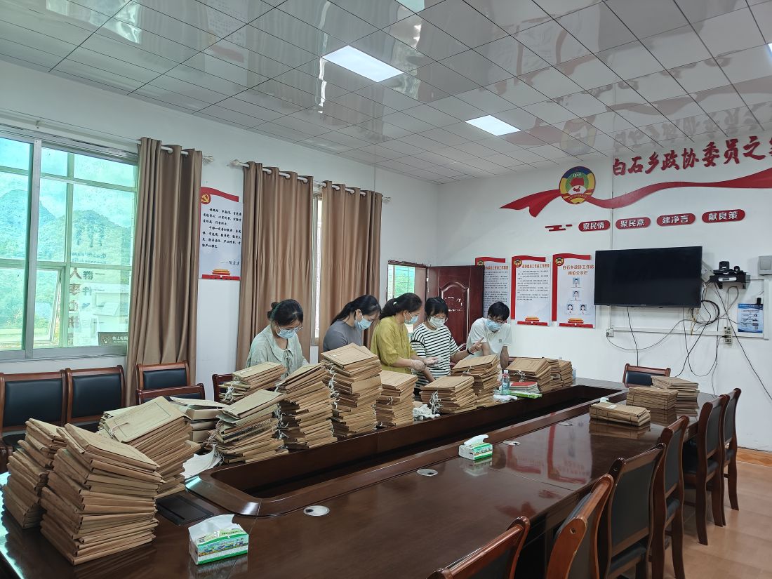 图为兴安县档案馆工作人员在白石乡人民政府指导协助整理档案.jpg